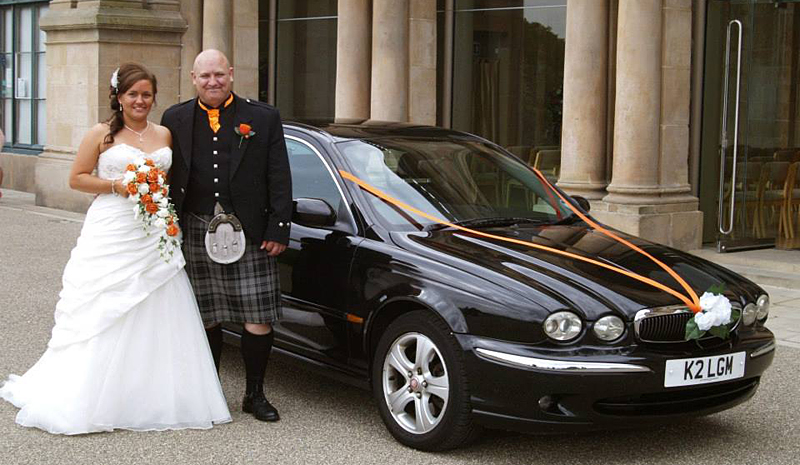 Couple outside their wedding next to Jaguar - Hire Class Cars Dundee - Weddings, special occasions